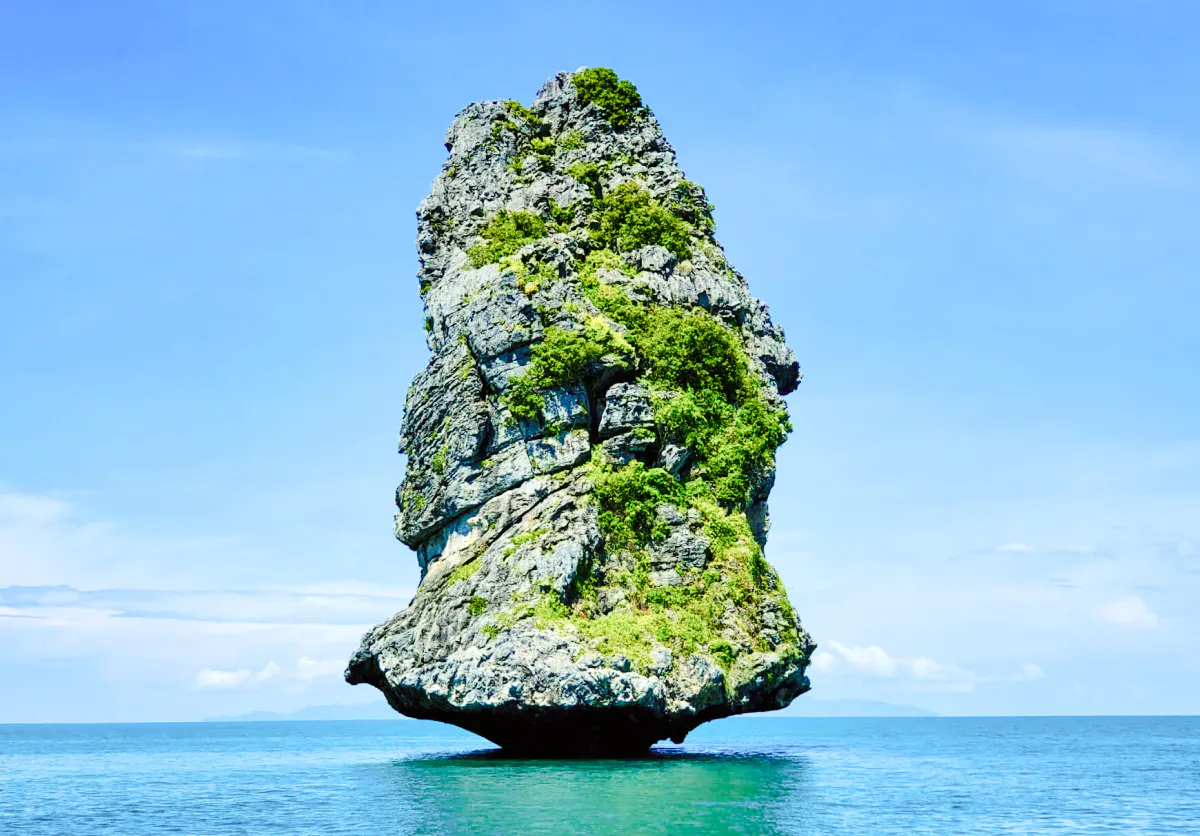 Rock formation in Ang Thong National Marine Park, Koh Samui, surrounded by blue sea.