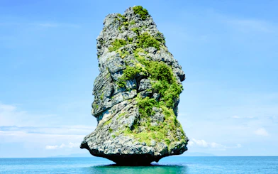Rock formation in Ang Thong National Marine Park, Koh Samui, surrounded by blue sea.