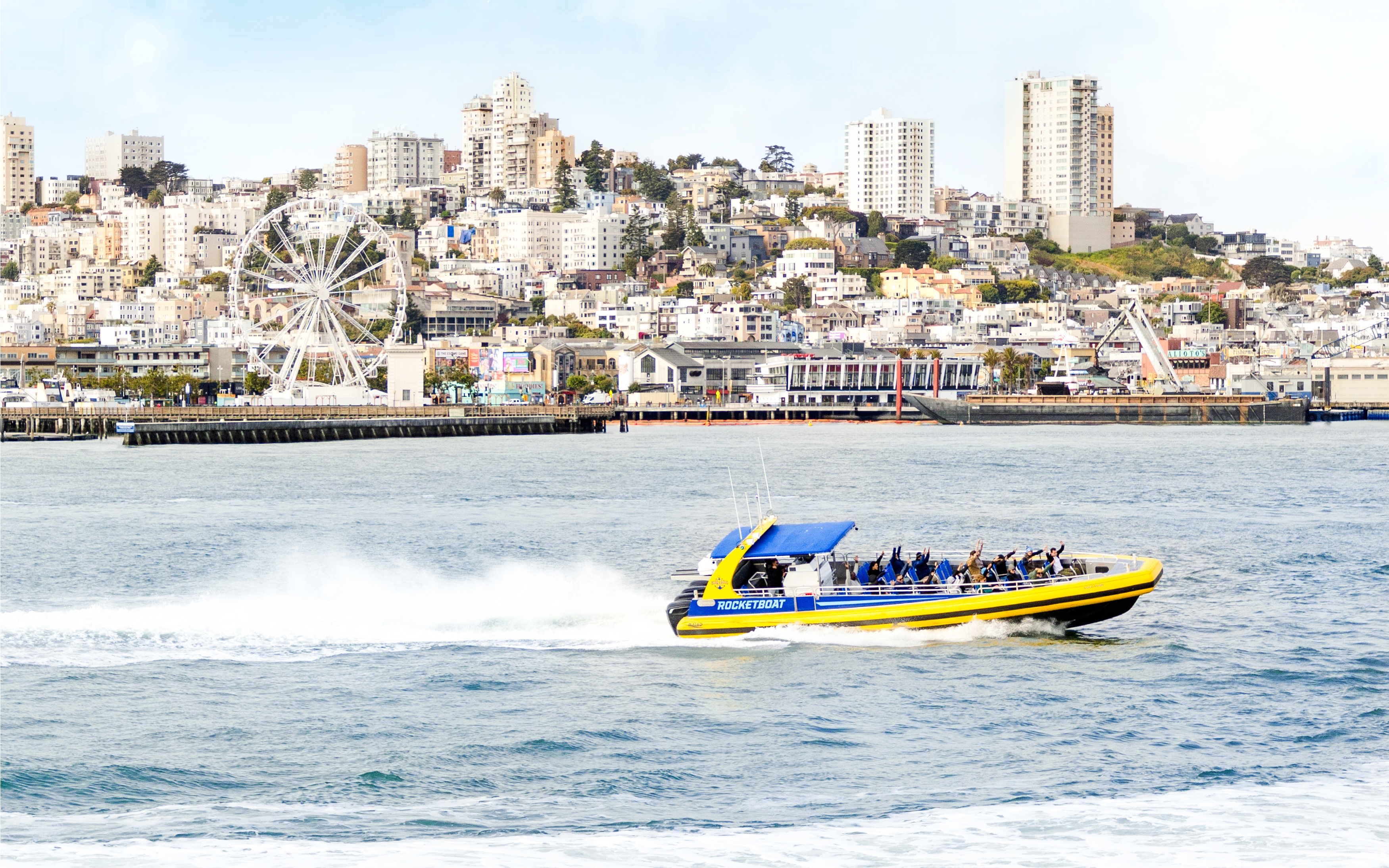 Rocketboat speeding across San Francisco Bay with city skyline in the background.