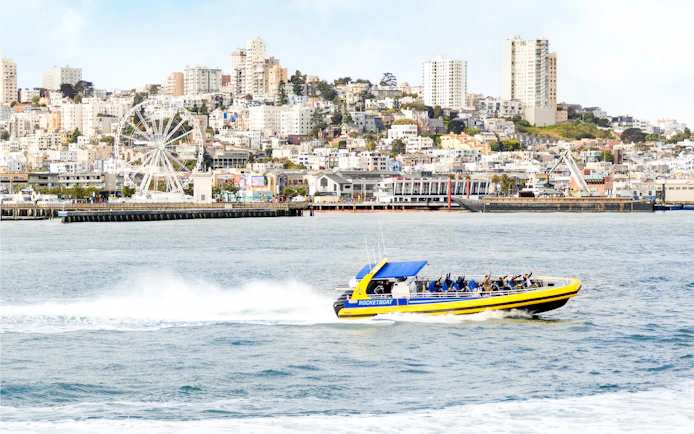 Rocketboat speeding across San Francisco Bay with city skyline in the background.