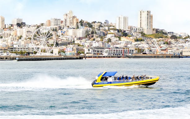 Rocketboat speeding across San Francisco Bay with city skyline in the background.
