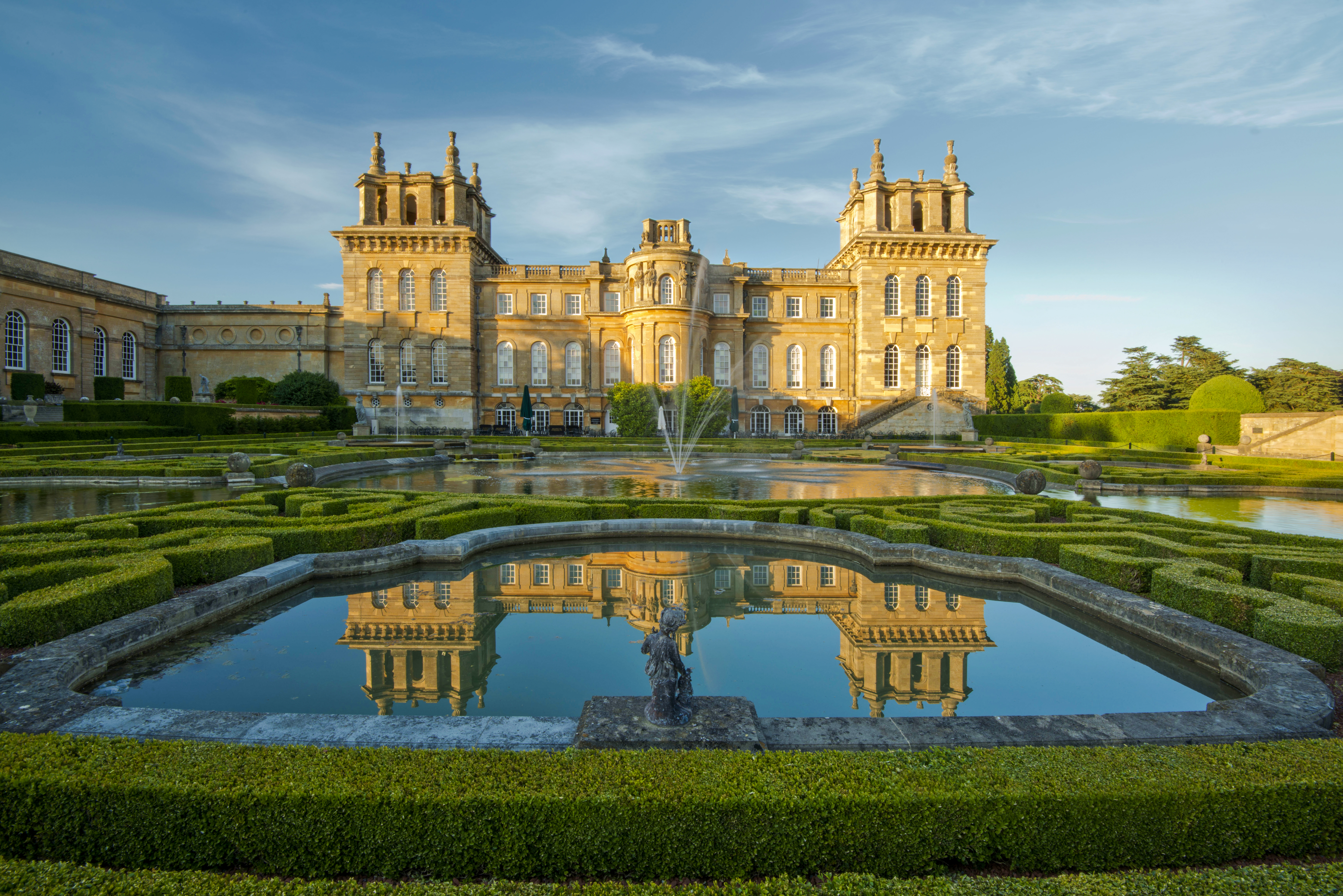 Blenheim Palace exterior with gardens and reflecting pool in Oxfordshire, England.