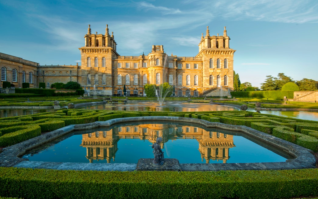 Blenheim Palace exterior with gardens and reflecting pool in Oxfordshire, England.