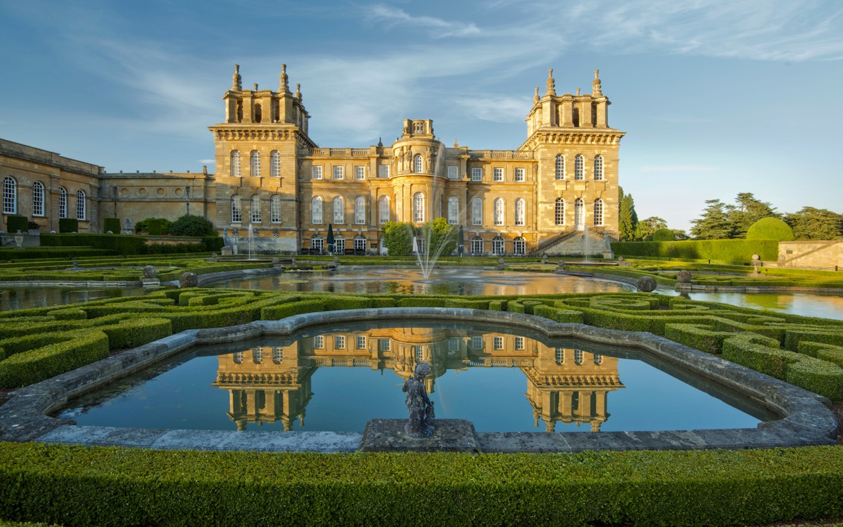 Blenheim Palace exterior with gardens and reflecting pool in Oxfordshire, England.