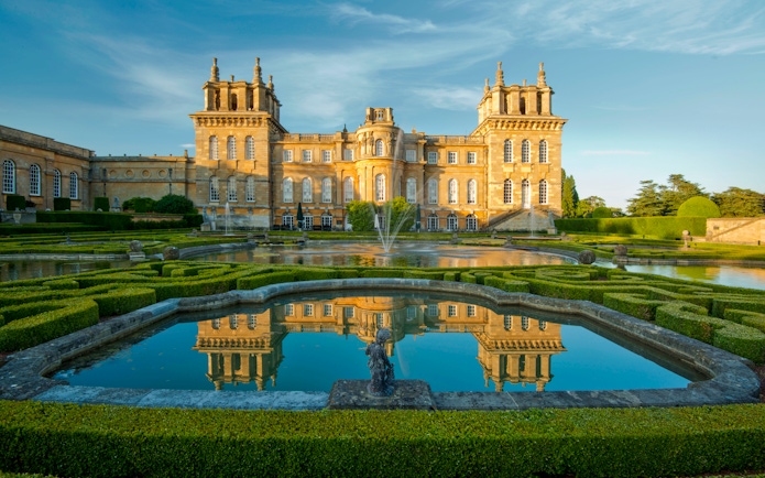 Blenheim Palace exterior with gardens and reflecting pool in Oxfordshire, England.