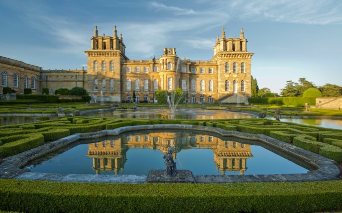 Blenheim Palace exterior with gardens and reflecting pool in Oxfordshire, England.