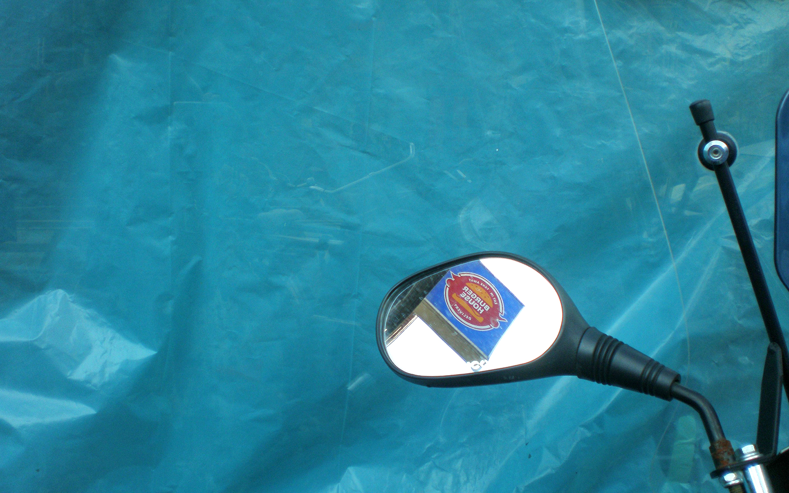 Motorcycle mirror reflecting exhibit sign at KBr Fundación MAPFRE Barcelona Photo Center.
