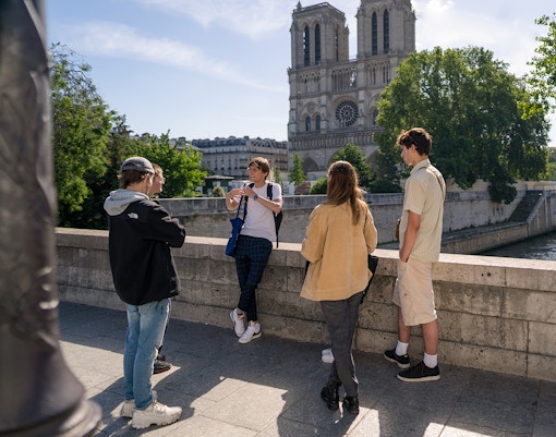 Guided tour group near Notre Dame Cathedral, Paris, exploring historic architecture.