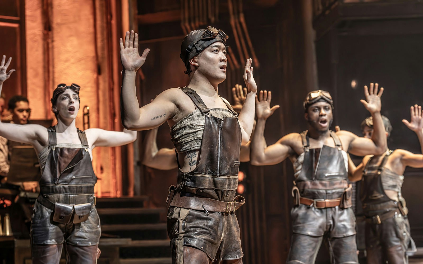 Performers in leather outfits on stage during a ghost stories theatrical production.