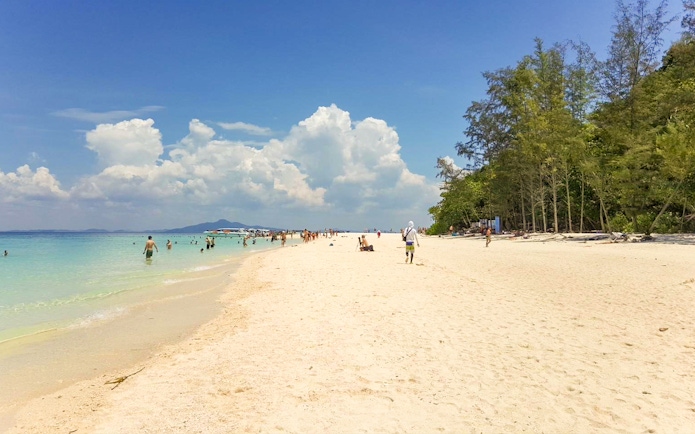 People enjoying the beach and swimming at Nui Beach, Phuket.