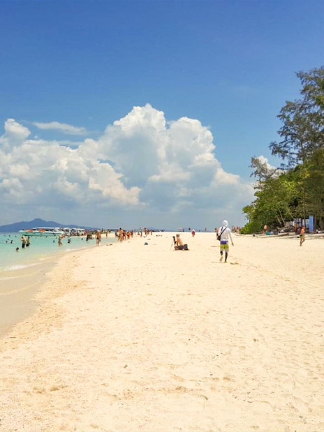 People enjoying the beach and swimming at Nui Beach, Phuket.