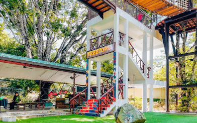 Treetop adventure area at Crocodile Adventureland Langkawi with colorful stairs and greenery.