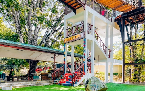 Treetop adventure area at Crocodile Adventureland Langkawi with colorful stairs and greenery.