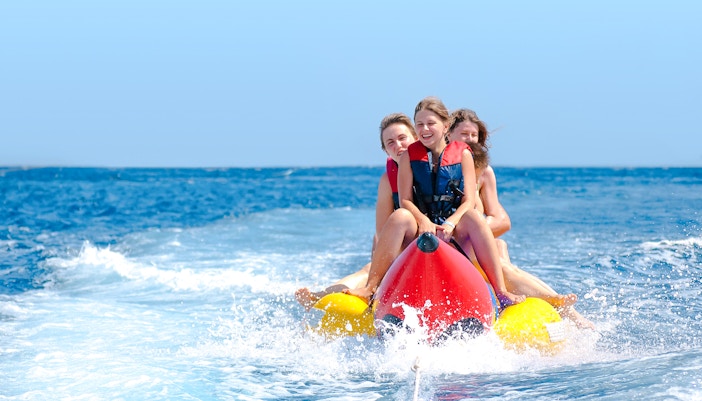 People enjoying a banana boat ride on the ocean.