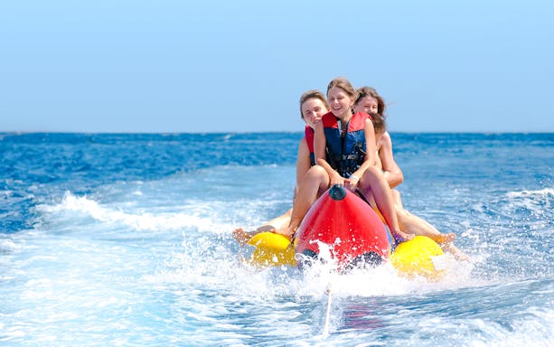 People enjoying a banana boat ride on the ocean.