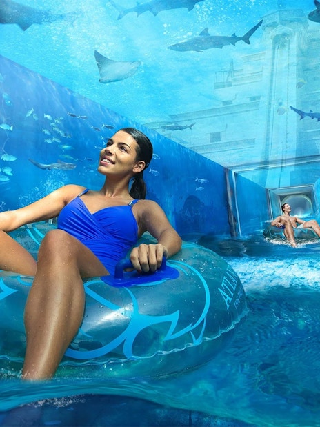 Visitors enjoying a water ride surrounded by marine life at Aquaventure, Atlantis Dubai.