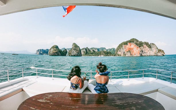 Premium yacht cruising near limestone cliffs during James Bond Sunset Tour, Phuket, Thailand.