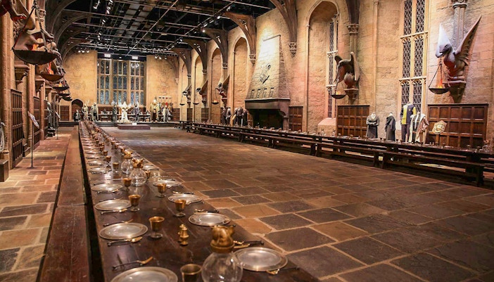 Great Hall at Harry Potter Exhibit with long tables and floating candles, London.