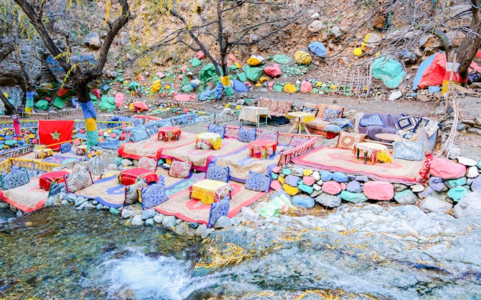 Colorful seating area by a stream in Setti Fadma, Ourika Valley, Morocco.