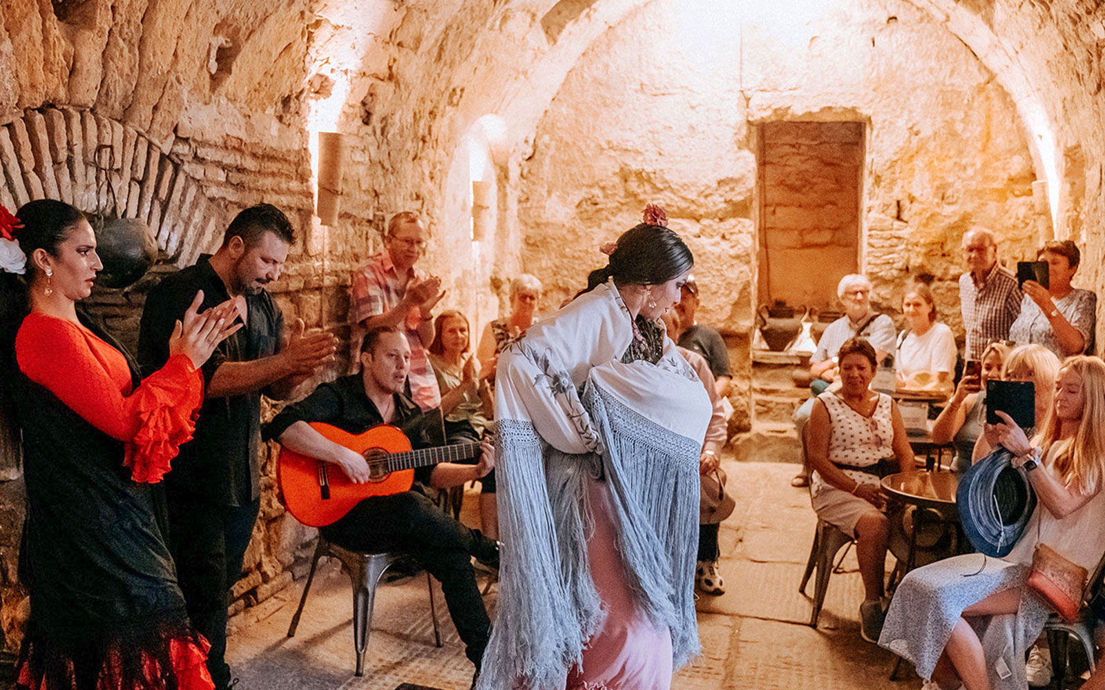 Flamenco dancer performing at Tablao Arab Baths of Santa María with audience watching.