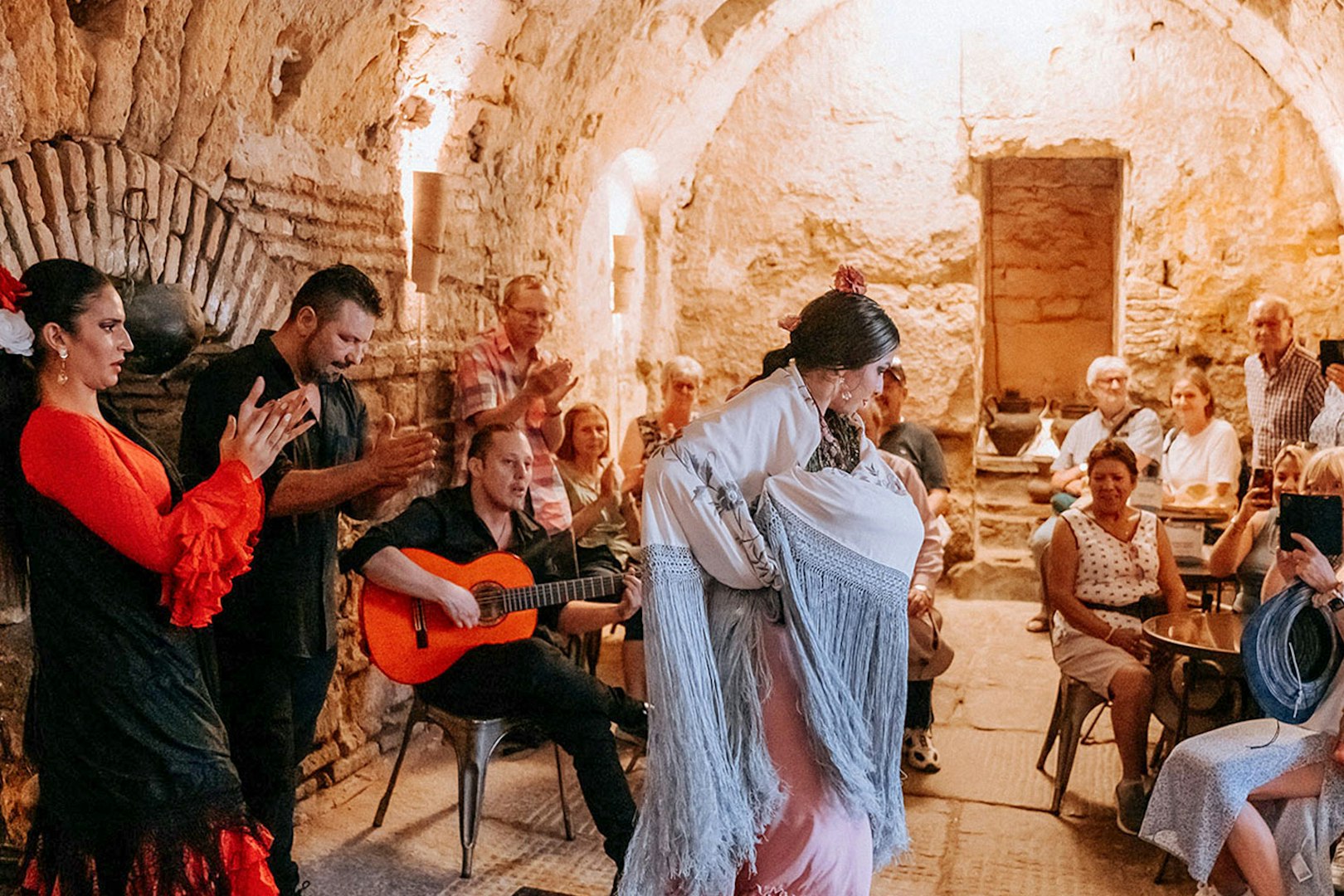 Flamenco dancer performing at Tablao Arab Baths of Santa María with audience watching.