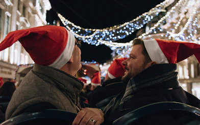 People wearing Santa hats on a Tootbus tour viewing London Christmas lights.