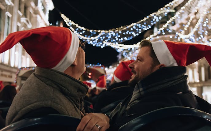 People wearing Santa hats on a Tootbus tour viewing London Christmas lights.