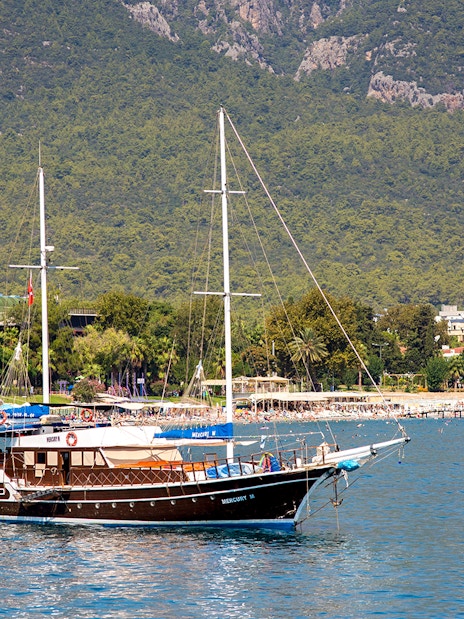 Boat sailing near Phaselis with lush mountains in the background, Antalya tour.
