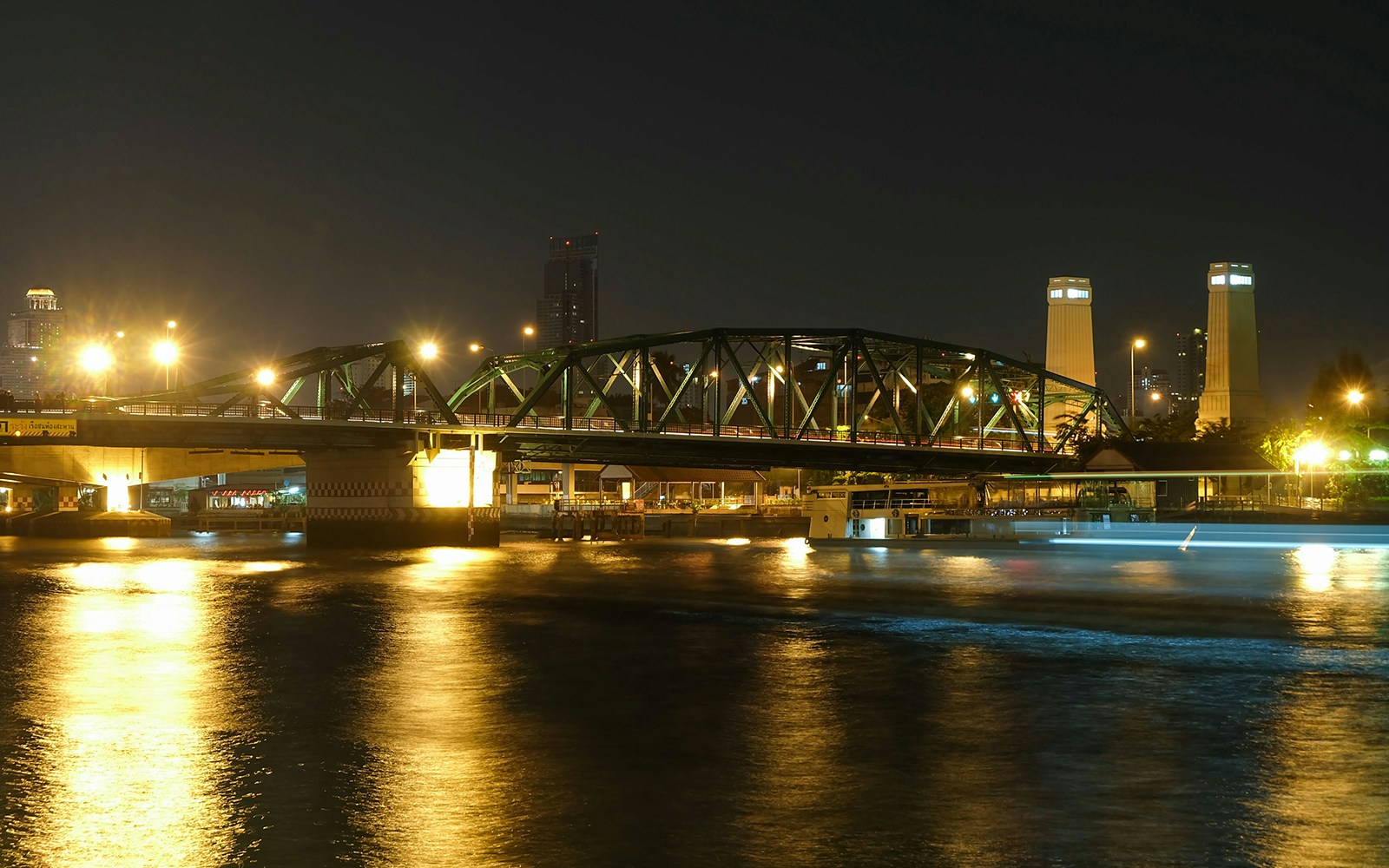 Saphan Phut Memorial Bridge illuminated at night over Chao Phraya River, Bangkok.