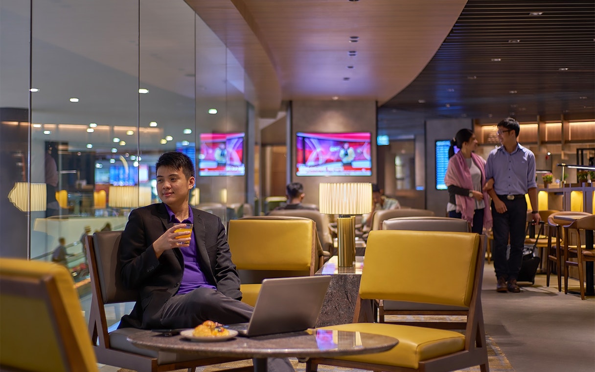 Man enjoying a drink at Plaza Premium Lounge, Kuala Lumpur International Airport.