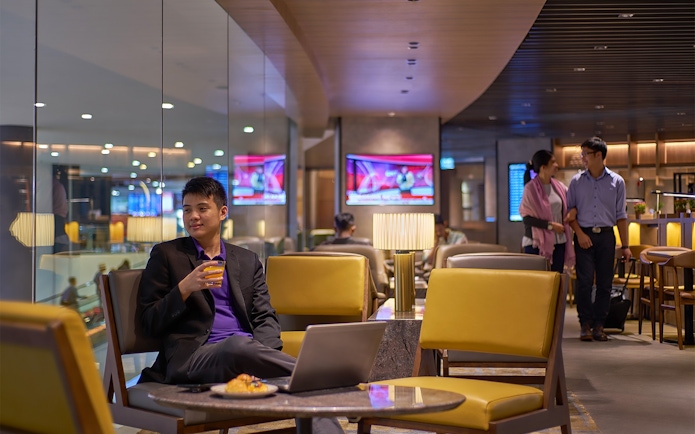 Man enjoying a drink at Plaza Premium Lounge, Kuala Lumpur International Airport.