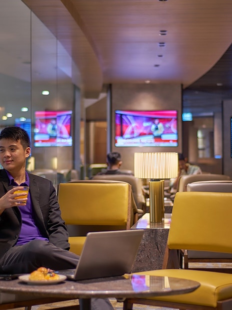Man enjoying a drink at Plaza Premium Lounge, Kuala Lumpur International Airport.