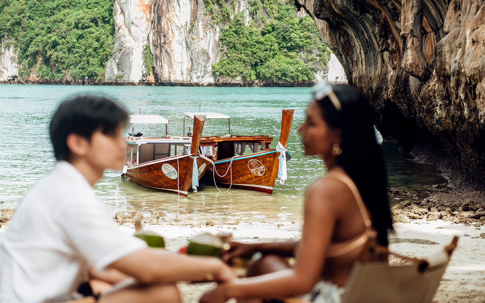 Longtail boat anchored near Krabi limestone cliffs, part of Neptune Boat & Leisure private charter.