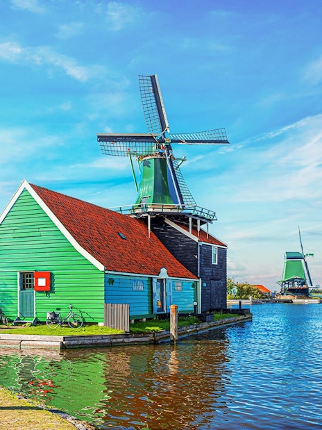 Windmill and green house by the water in Zaanse Schans, Netherlands.