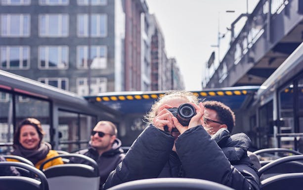 Tourist taking photos on Hamburg Hop-On Hop-Off bus tour.