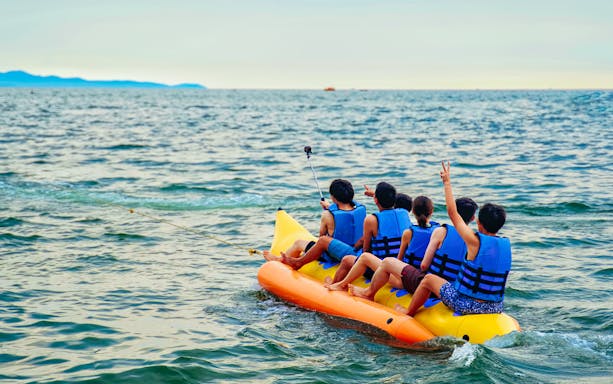 Group enjoying a banana boat ride on the ocean.