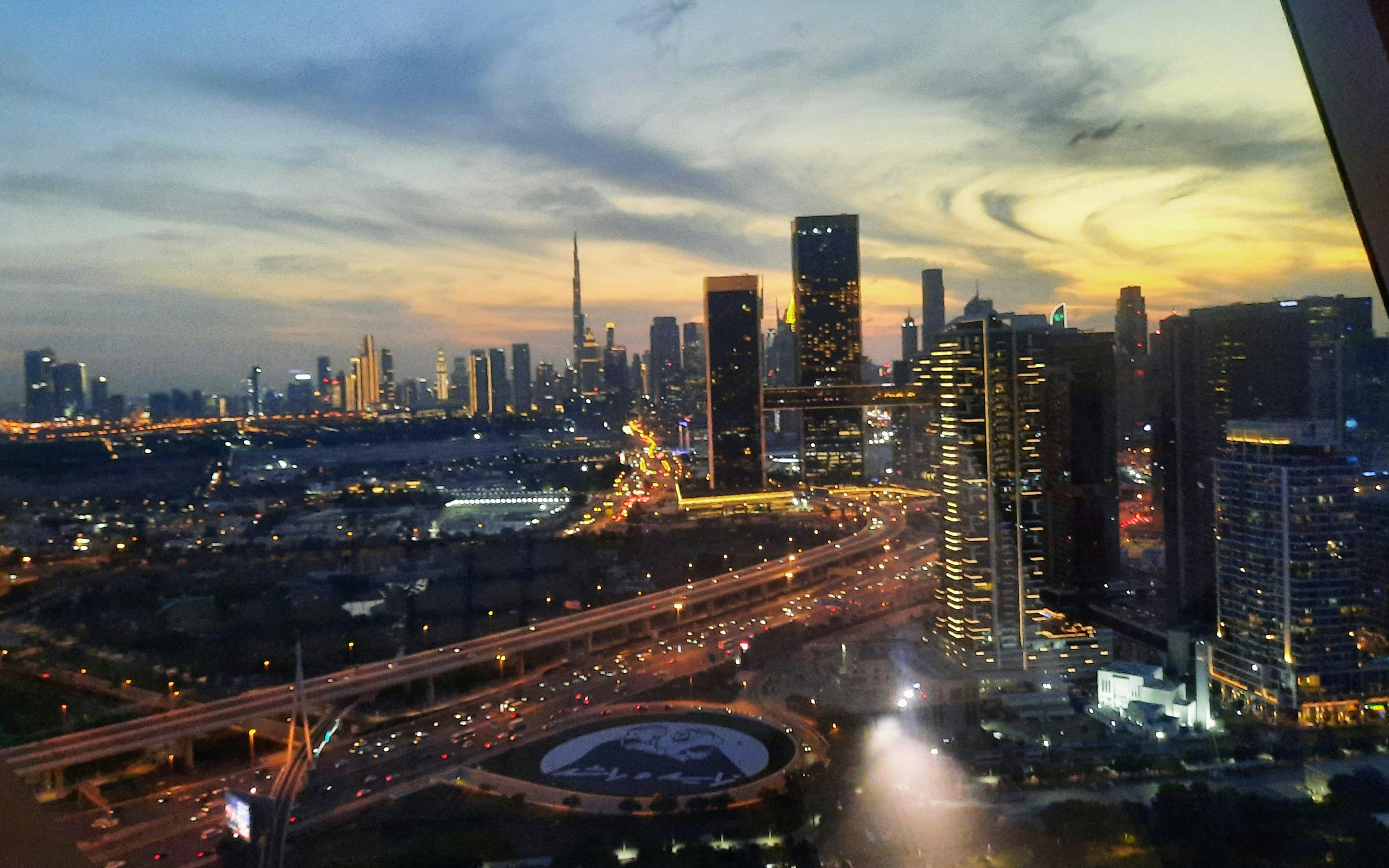 Illuminated Dubai skyline at sunset viewed from Dubai Frame, featuring Burj Khalifa.