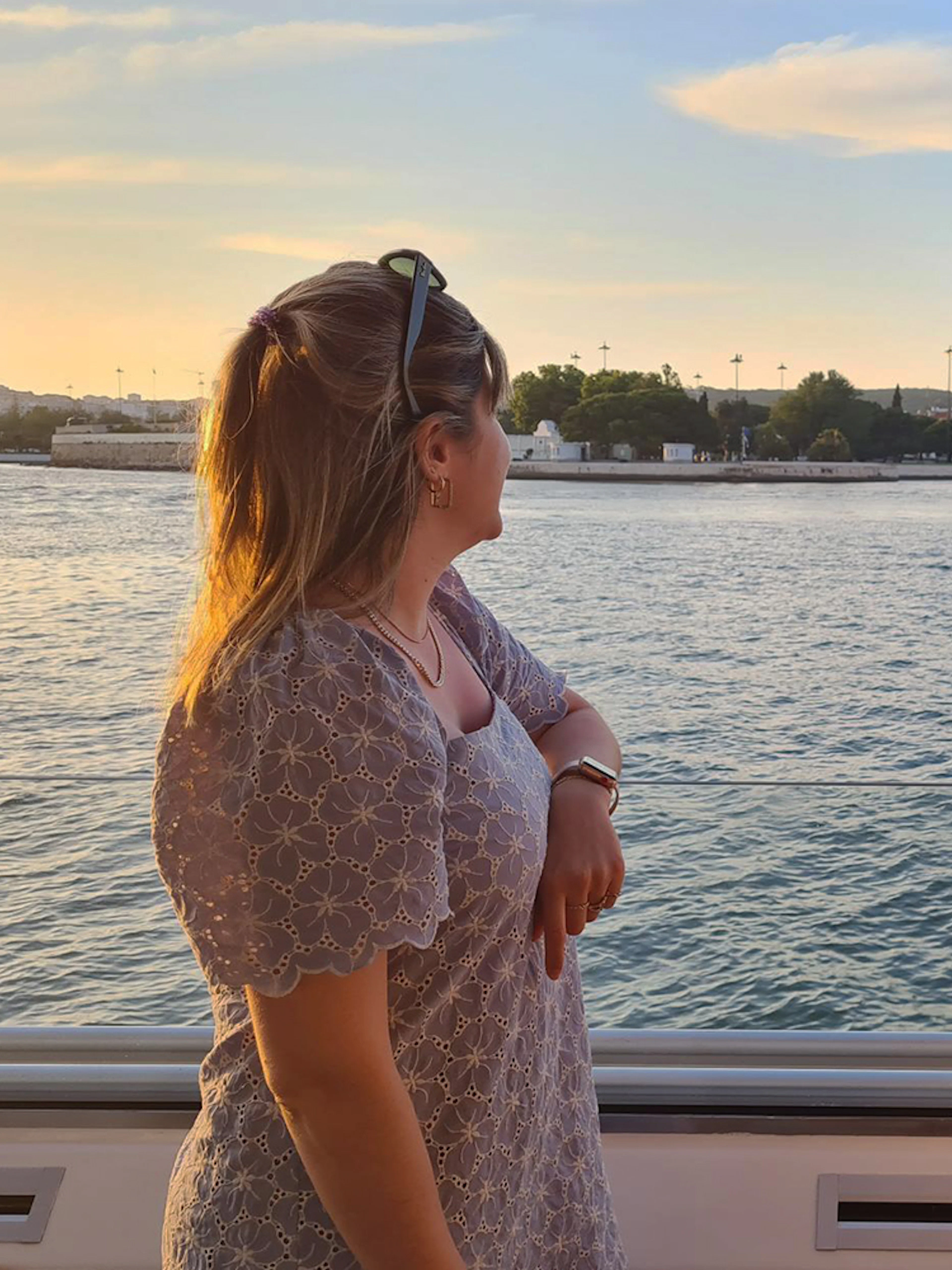 Two people enjoying a view of Belém Tower from a boat on the Tagus River.