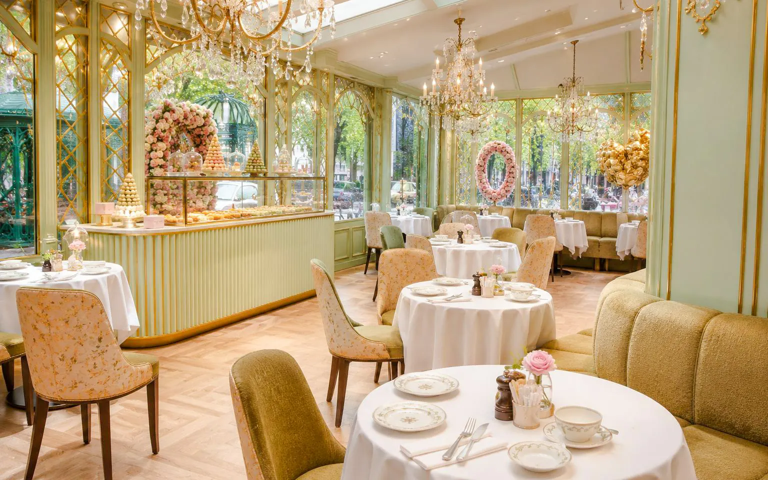Ladurée tea room interior near Orsay Museum, Paris, with elegant tables and pastry display.