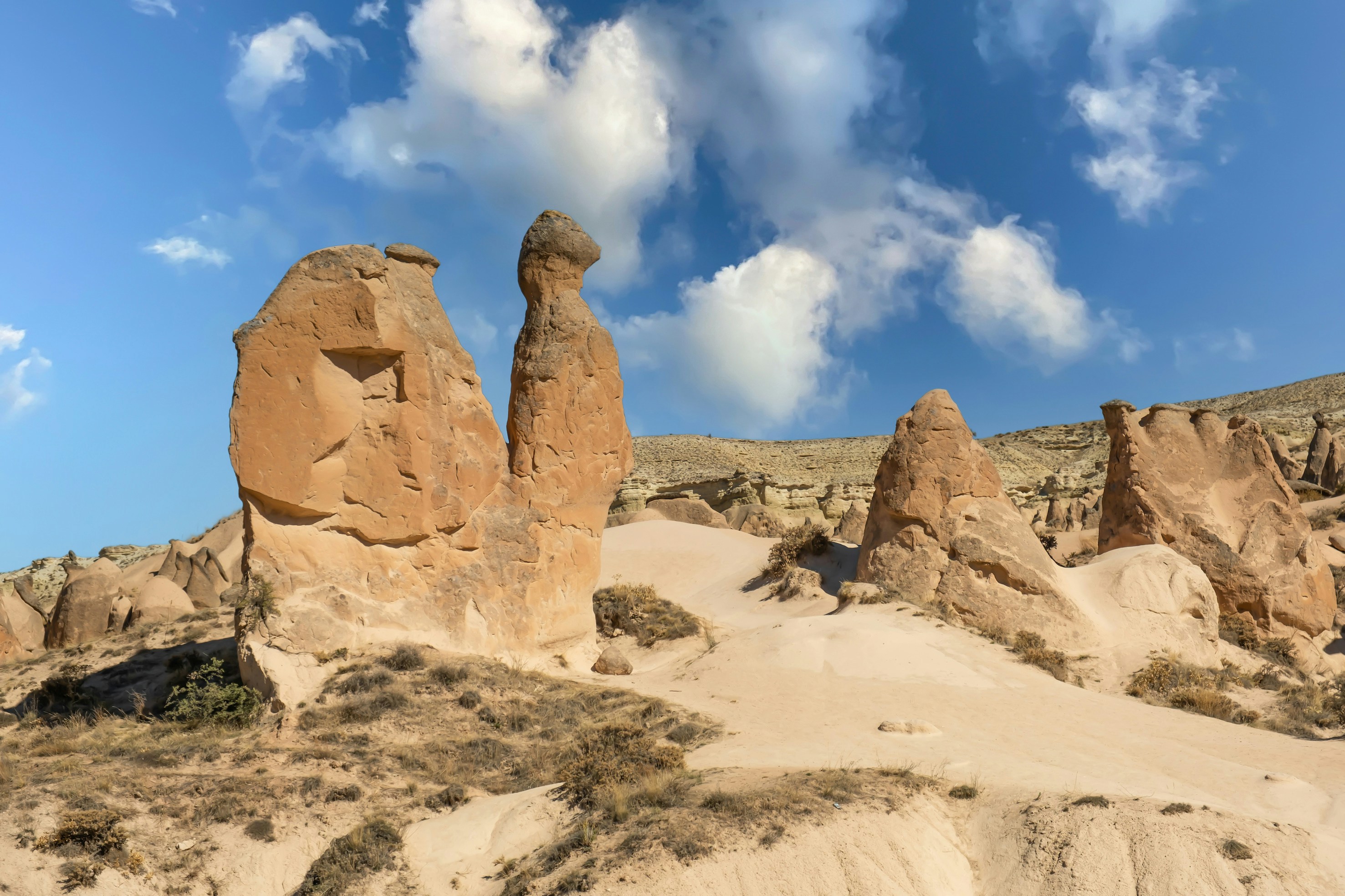 Rock formations in Devrent Valley, Cappadocia, under a blue sky.