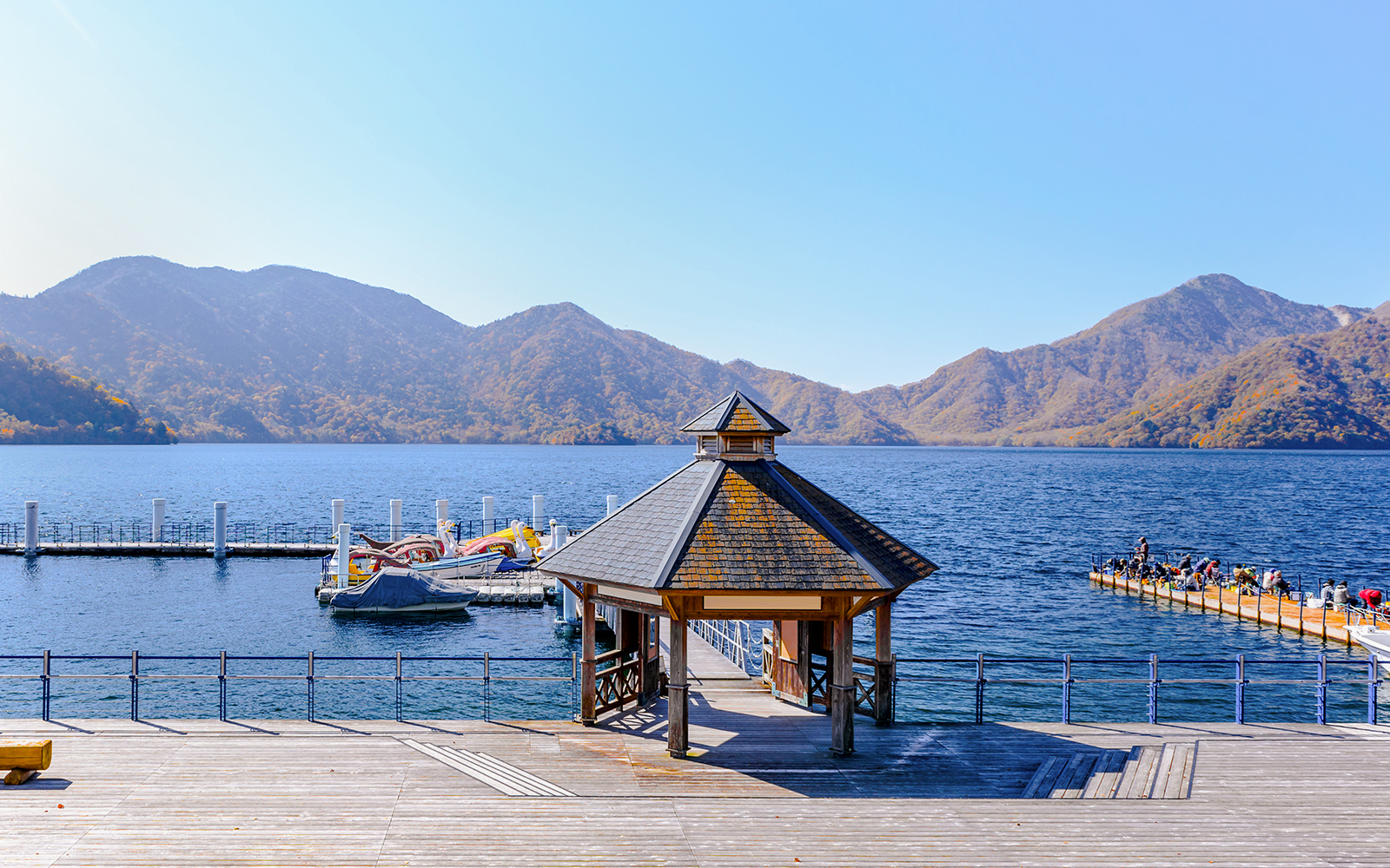 Pier and gazebo at Chuzenji Lake in Nikko with mountains in the background.
