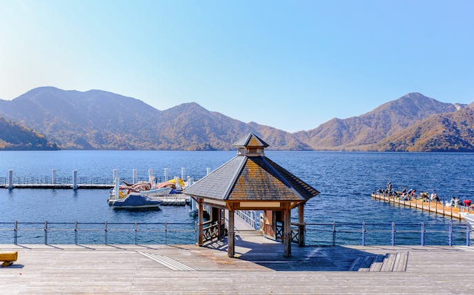 Pier and gazebo at Chuzenji Lake in Nikko with mountains in the background.