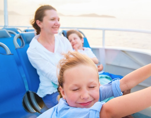 Family enjoying ferry ride with ocean view.