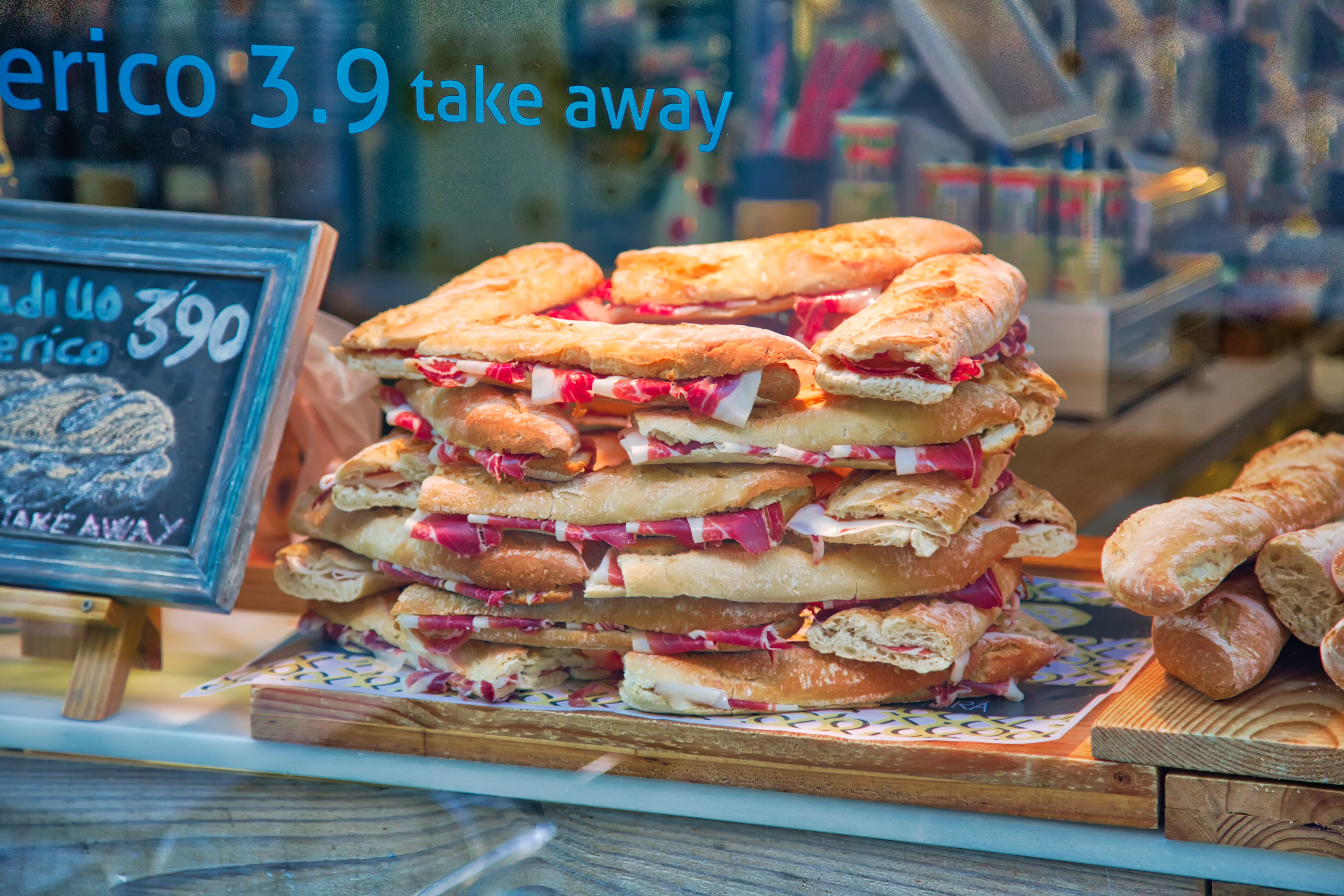 Spanish jamon sandwiches stacked in a Granada city center shop window.