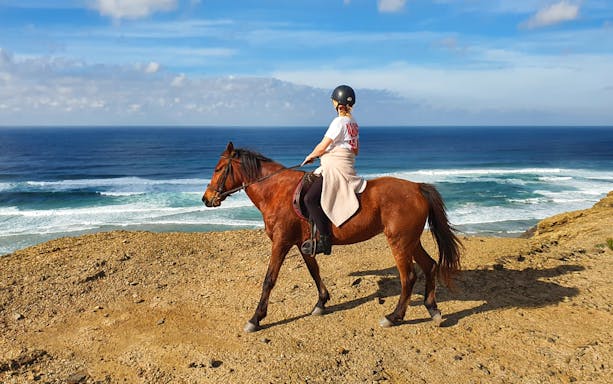 Horse riding along the scenic coastline of Carrapateira, Portugal.