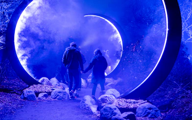 Visitors walking through illuminated portal at Astra Lumina, Currumbin Wildlife Sanctuary.