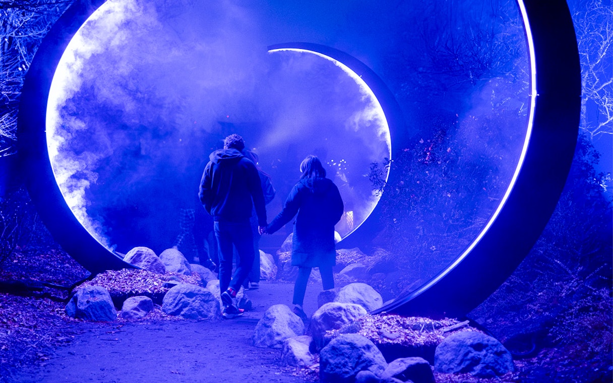 Visitors walking through illuminated portal at Astra Lumina, Currumbin Wildlife Sanctuary.