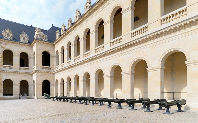 Courtyard of the Army Museum in Paris with historic cannons on display.