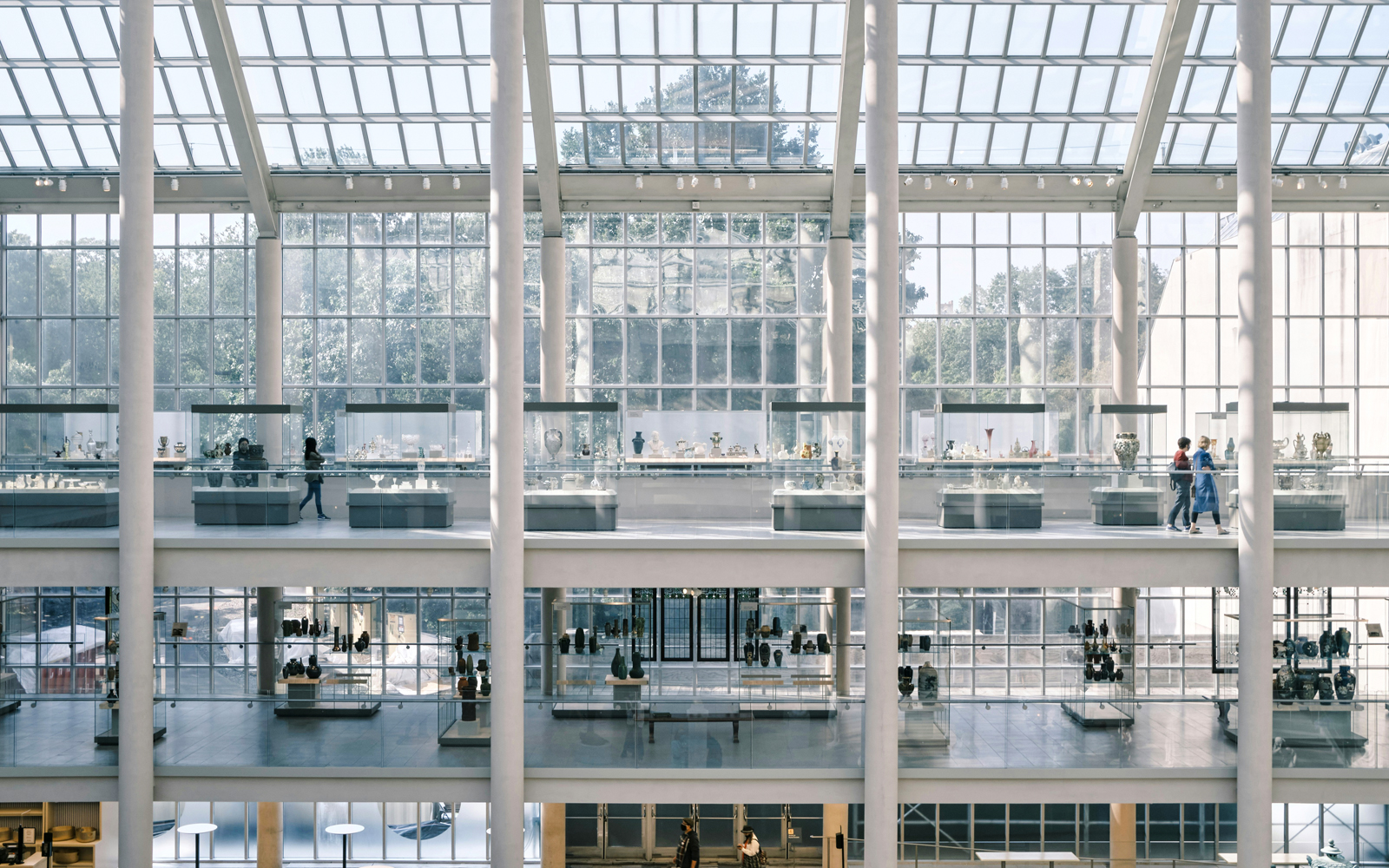 Interior view of the Metropolitan Museum of Art, New York, showcasing glass display cases and visitors.