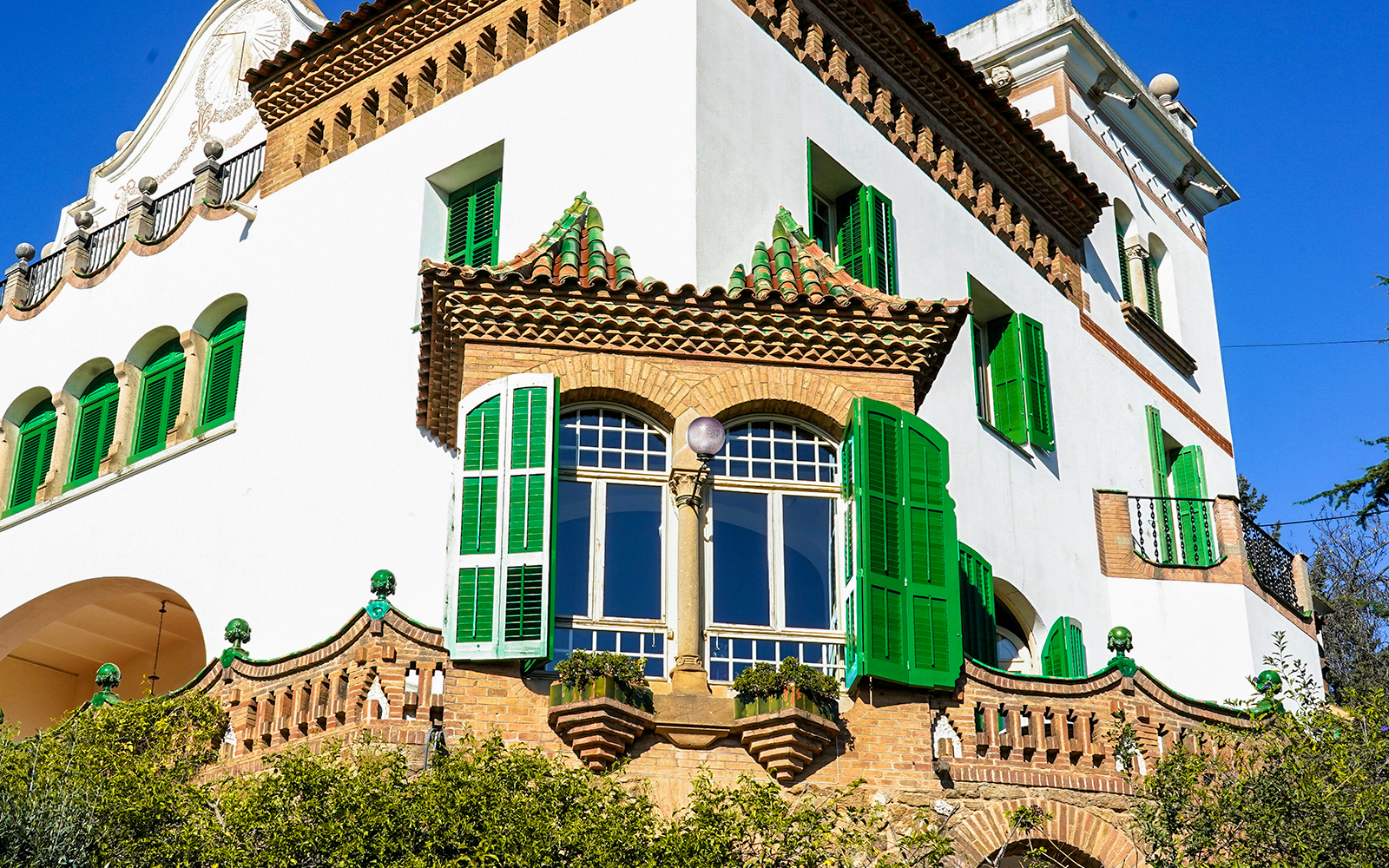Casa Trias facade with green shutters and decorative windows in Barcelona.